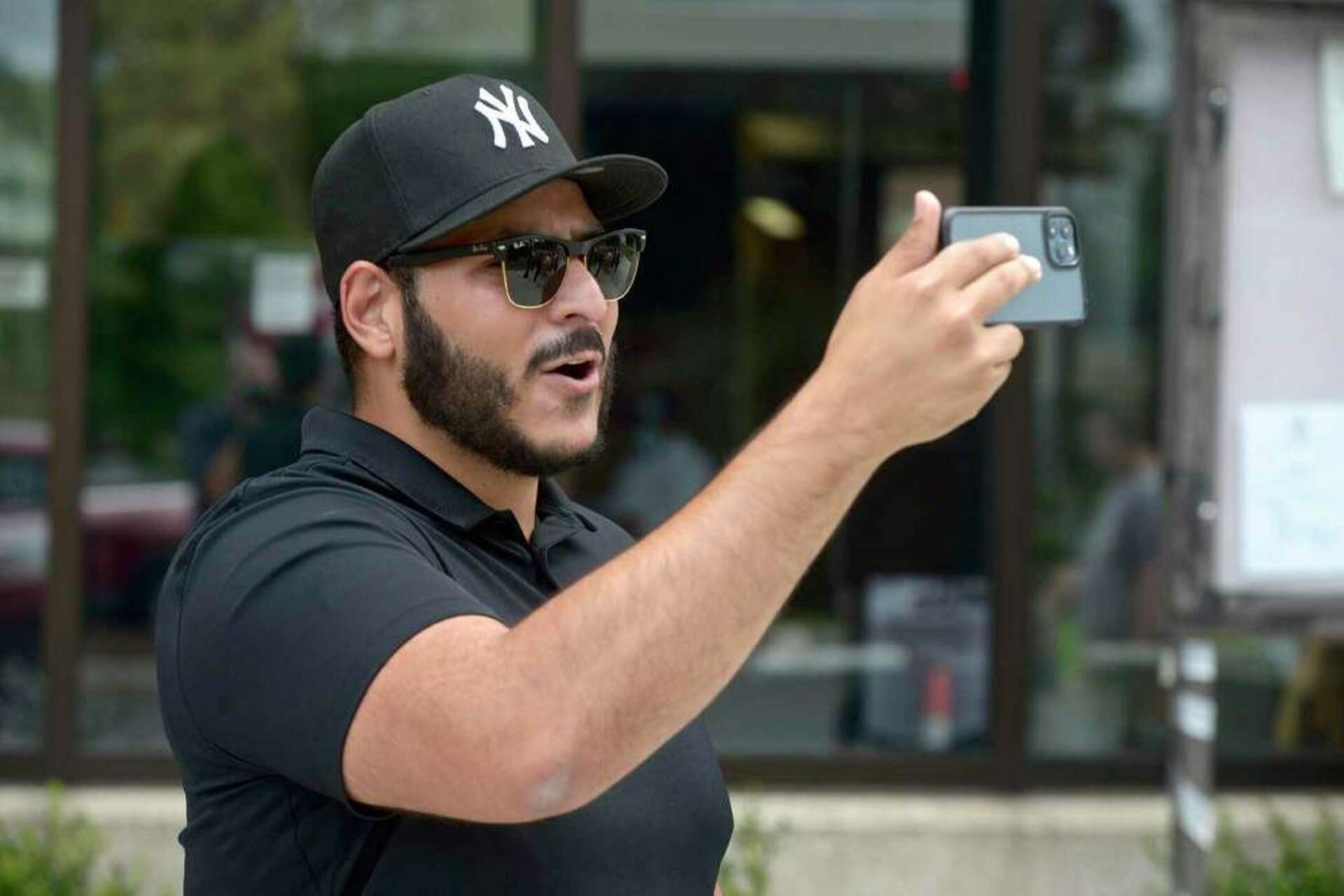 SeanPaul Reyes, host of Long Island Audit, filming on a public sidewalk